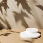 Abstract minimal nature scene with white podium on beige background and leaves shadows