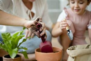 Kid DIY plant potting at home with mom